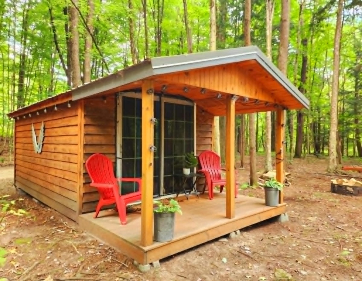 Bodhi's Bunkhouse, a wooden cabin with red porch chairs among the pines
